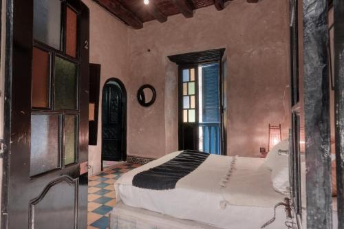 a bedroom with a large bed and a window at Riad Beldy in Essaouira