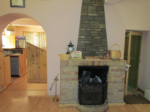a living room with a stone fireplace in a house at Hotel Germenji in Gërmenji