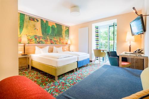ローアにあるBoutique Hotel Bundschuh 3 Sterne Superiorのベッドルーム1室(ベッド2台、デスク、テレビ付)