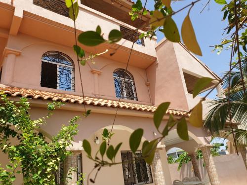 a building with windows and trees in front of it at Villa Savana in Saly Portudal