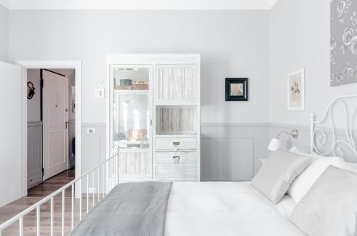 Un dormitorio blanco con una cama blanca y una escalera en Il Cottage, en Vigevano
