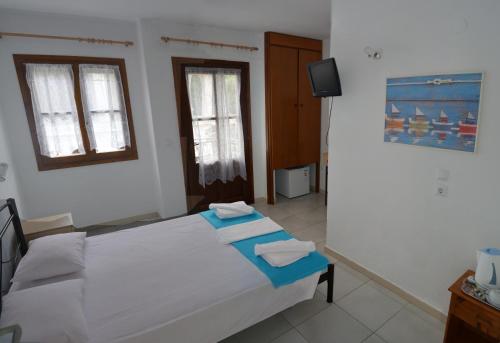 a bedroom with a bed with towels on it at Villa Molos in Limenas
