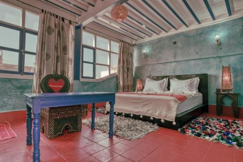 a bedroom with a bed and a table in it at Riad Beldy in Essaouira
