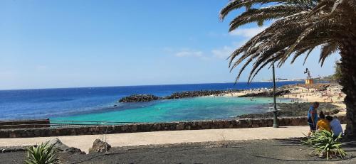 a group of people standing next to a beach at CASA JABLILLO in Costa Teguise