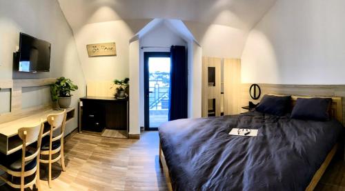 a bedroom with a bed and a desk and a television at Be.Ho DaLat - Attic in Da Lat