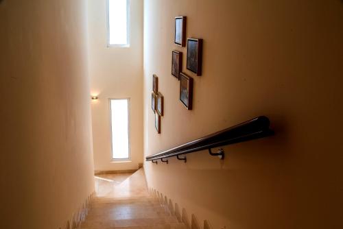 a hallway with a staircase with a window and pictures on the wall at Vivienda Hotel Villas in Riyadh