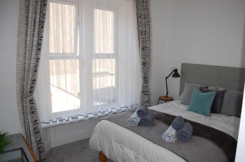 Central Living Apartment في ويستون سوبر مير: غرفة نوم عليها سرير وفوط زرقاء