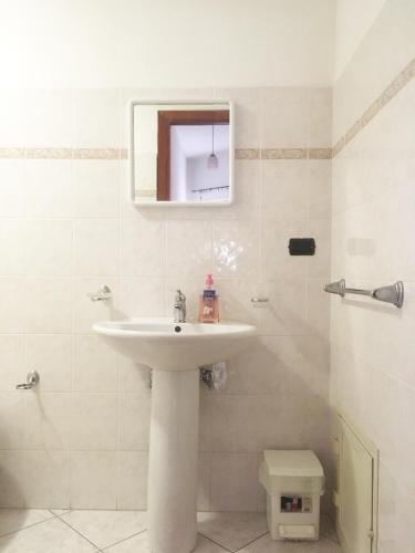 a bathroom with a sink and a toilet and a mirror at Bed and Breakfast da Antonio - Orgosolo in Orgosolo