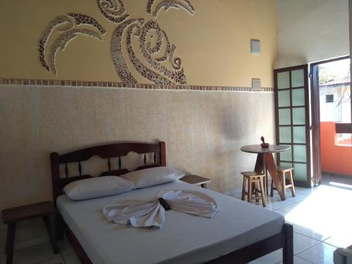 Un dormitorio con una cama con una toalla. en Pousada Refúgio D´Mar, en Ubatuba