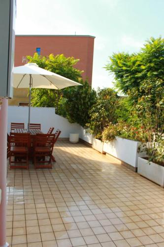 a patio with a table and an umbrella at Casa Romana in Spinetta Marengo