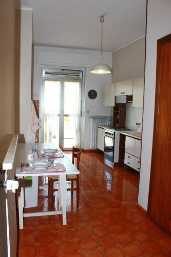 a living room with a table and a kitchen at Casa Romana in Spinetta Marengo