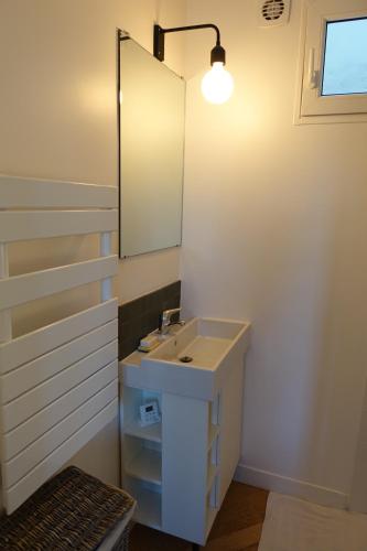 bagno con lavandino e specchio di Sunny and quiet apartment a Parigi