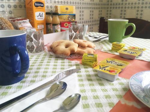 a table with some donuts on a table with spoons at Bed and Breakfast da Antonio - Orgosolo in Orgosolo