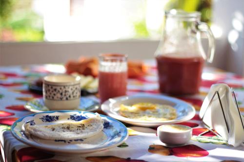 a table with plates of breakfast food and a pitcher of juice at Doce Lar Hospedaria in Lençóis