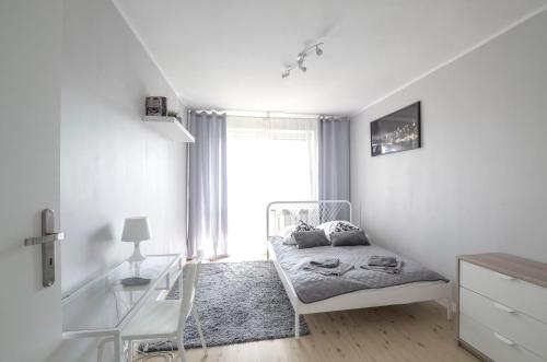 Habitación blanca con cama y ventana en Stanisława Dubois 29, Wrocław, en Wroclaw