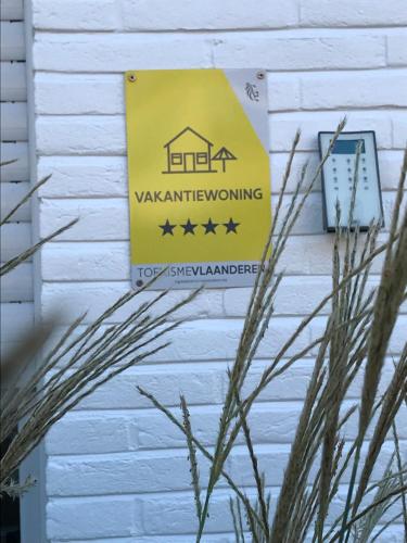 a sign on the side of a building with stars at Vakantiewoning Margaux -free parking - Sauna in Bruges