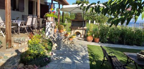 a garden with a fireplace and a table and chairs at Pelion Platanidia seaside house in Platanidia