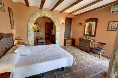 ChellaにあるCasa Rural Mirador del Saltoのベッドルーム1室(大型ベッド1台、アーチ型の入り口付)