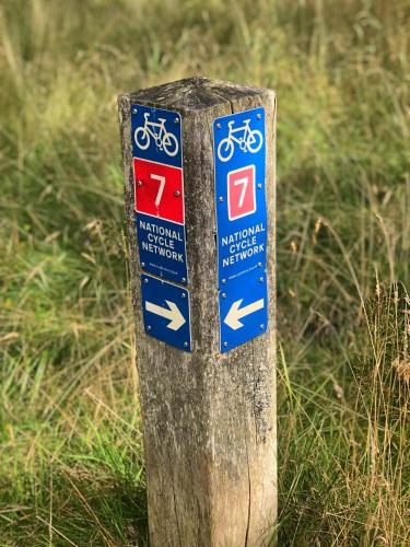 a sign on a wooden post in the grass at Linmore in Aviemore