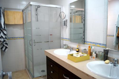 a bathroom with a sink and a glass shower at Best Views Meloneras Deluxe 113 in San Bartolomé de Tirajana