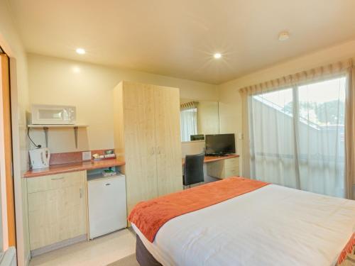 a hotel room with a bed and a window at Bella Vista Motel Greymouth in Greymouth