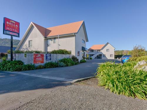 a house with a sign in front of a driveway at Bella Vista Motel Greymouth in Greymouth