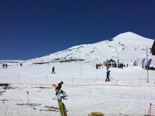 a group of people skiing on a snow covered mountain at Condominio Robles camino al volcan in Pucón
