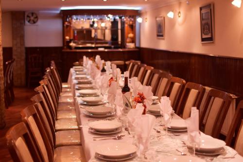 una mesa larga con platos y servilletas. en Hotel Gran Libertador, en Potosí