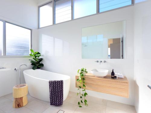 a bathroom with a large tub and a sink at Absolute Waterfront in Gerroa