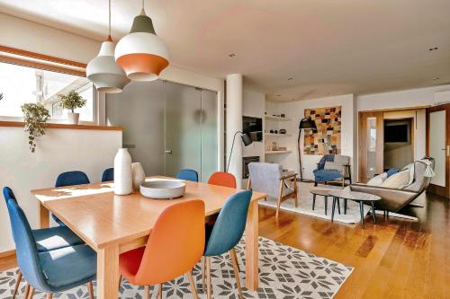 a dining room and living room with a table and chairs at Charming Bonfim Penthouse in Porto