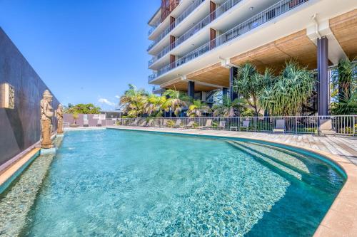 a swimming pool in front of a building at On The Beach Resort Bribie Island in Woorim