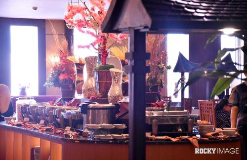 a counter with pots and pans and vases on it at Rocky Plaza Hotel Padang in Padang
