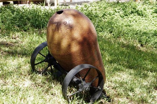 an old iron object sitting in the grass at Rochabus in Ica