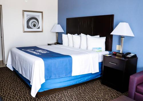 a hotel room with a large bed and a chair at Econo Lodge in Bryan