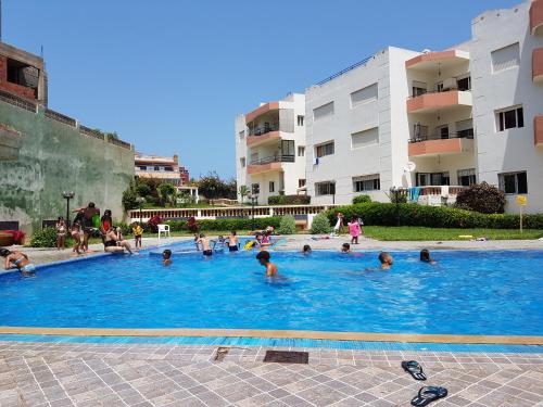 a group of people swimming in a swimming pool at Apartment in Mohamadaya Morocco in Mohammedia