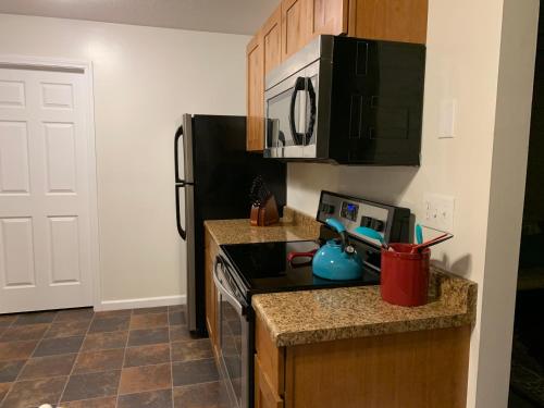 a small kitchen with a stove and a refrigerator at The Diamond at Kingston East in Rexburg