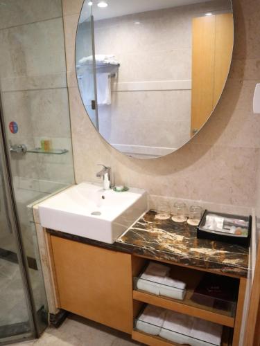 a bathroom with a sink and a mirror at 广州丹顿行政公寓珠江新城店-广交会期间免费穿梭巴士 in Guangzhou