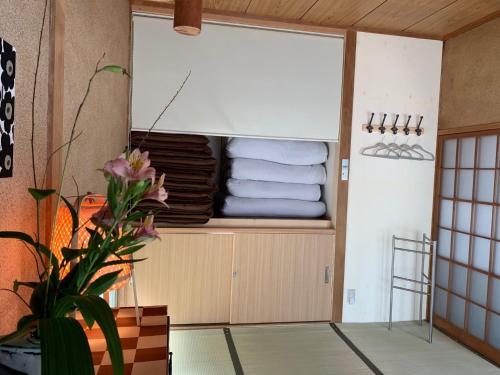 - un placard avec des serviettes et une plante dans la chambre dans l'établissement One Rest Private House, à Naoshima