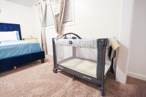 Una cuna en un dormitorio con cama en The Diamond at Kingston East, en Rexburg