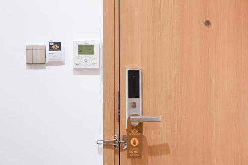 an open door with a cell phone on it at Prague Saigon Airport Hotel in Ho Chi Minh City