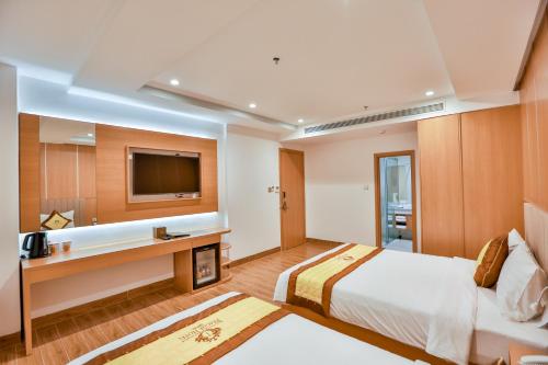 a hotel room with a bed and a tv at Prague Saigon Airport Hotel in Ho Chi Minh City