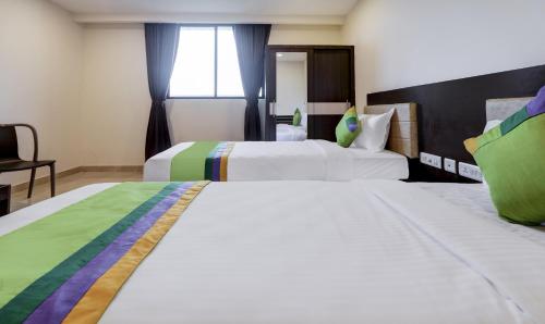 a hotel room with two beds and a window at Treebo The Horizon Kankanady in Mangalore