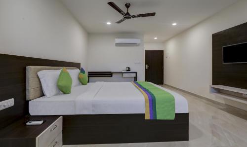 a bedroom with a large bed and a flat screen tv at Treebo The Horizon Kankanady in Mangalore