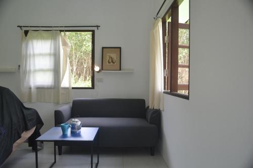 a living room with a couch and a table at Homebar in Ko Chang