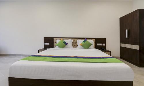 a bedroom with a large bed with a wooden headboard at Treebo The Horizon Kankanady in Mangalore