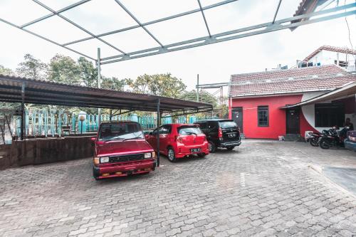 a group of cars parked in a parking lot at OYO 947 Angel Home Stay Syariah Near Atrium Pondok Gede, Museum Monumen Pancasila, Taman Mini in Jakarta