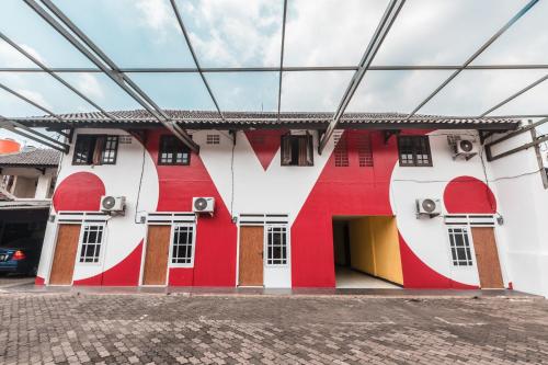 a building with red and white paint on it at OYO 947 Angel Home Stay Syariah Near Atrium Pondok Gede, Museum Monumen Pancasila, Taman Mini in Jakarta