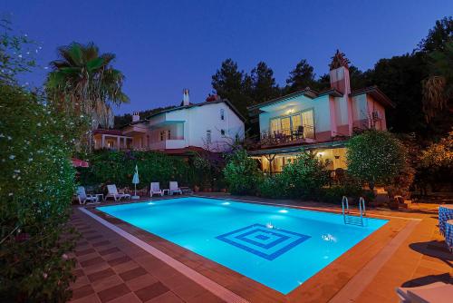 a swimming pool in front of a house at night at Villa Yasemin Aparts in Göcek