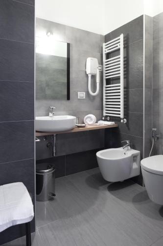 a bathroom with a sink and a toilet and a mirror at Motel Karibe in Fratta Polesine