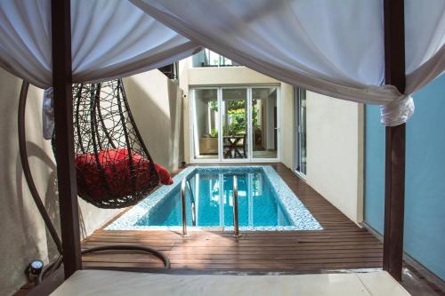 a swimming pool with a hammock next to a house at Kings Landing Unawatuna in Unawatuna